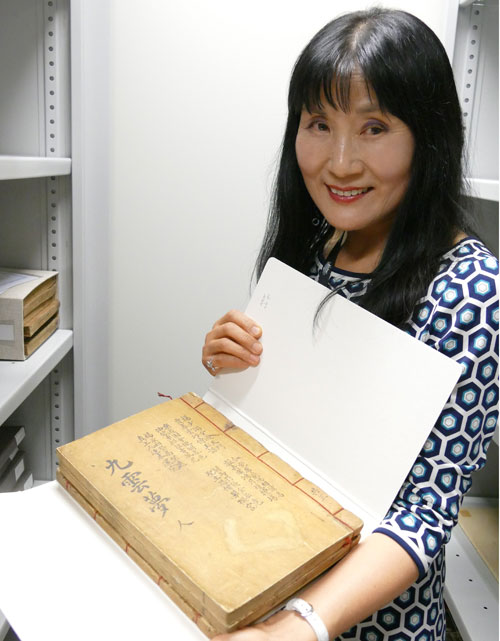 호주 캔버라의 호주국립도서관 한국과에서 25년 간 일하고 있는 사서 박정옥씨가 ‘구운몽’을 들고 미소를 짓고 있다. (2015.12.14.)
