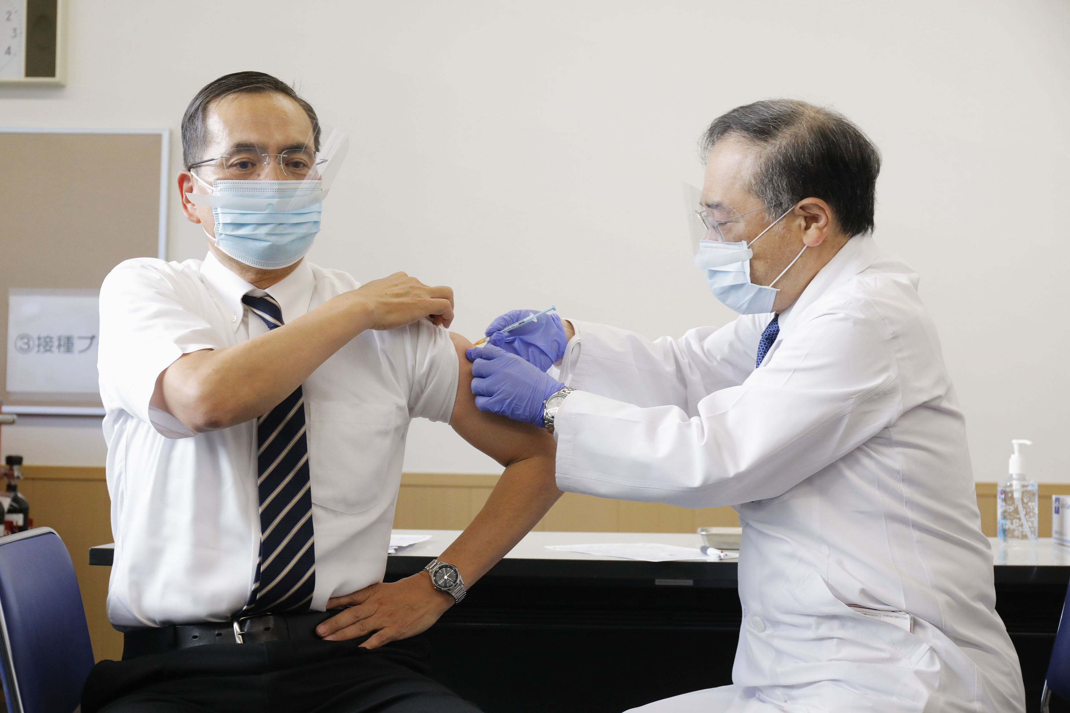 2021년 2월 17일 일본 내 코로나19 백신 첫 접종 대상자로 선정된 도쿄의료센터의 아라키 가즈히로(新木 一弘) 원장(왼쪽)이 백신 주사를 맞고 있다. (도쿄 교도=연합뉴스)