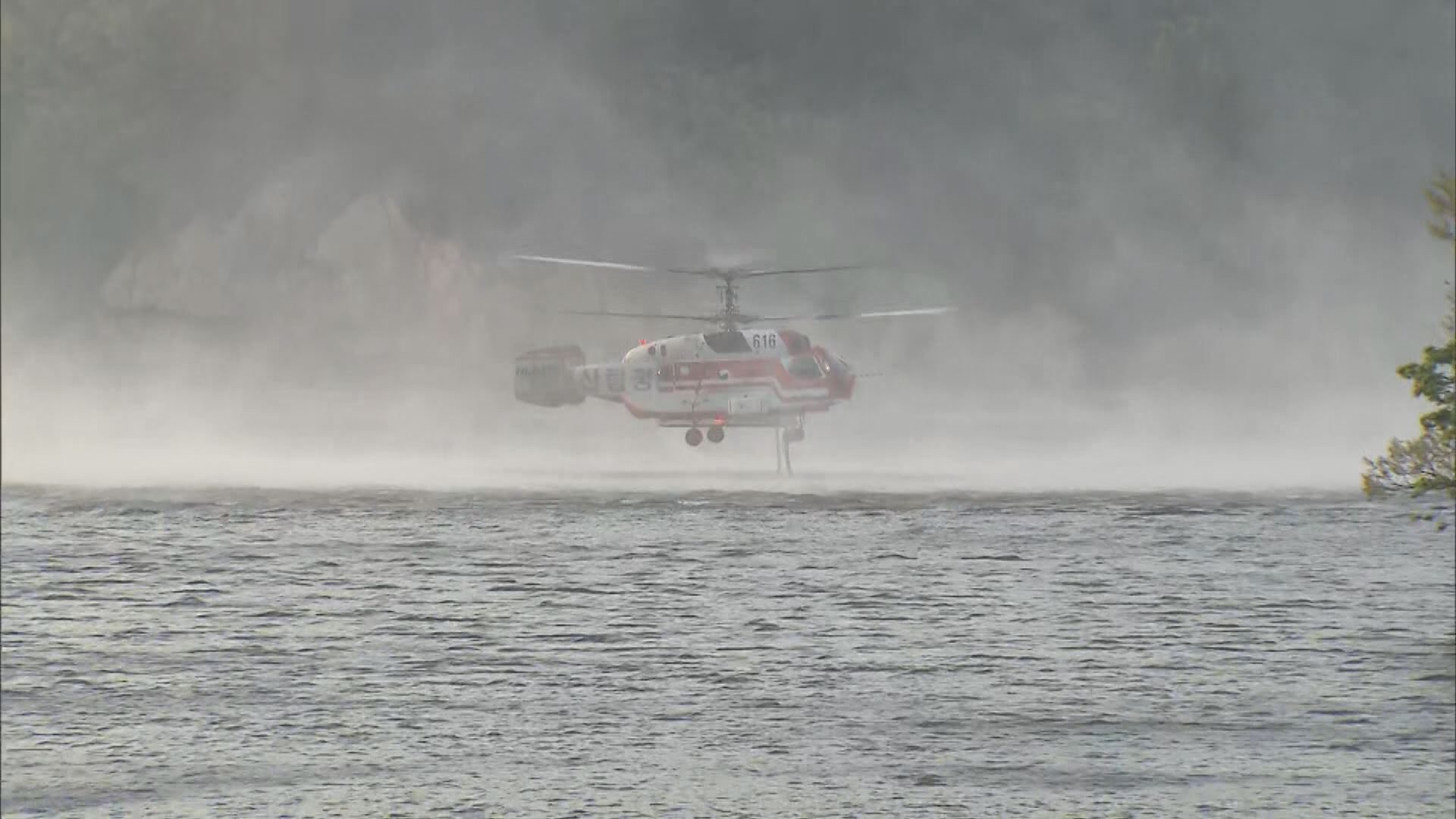  산림청 헬기가 산불 진화용 물을 싣는 ‘담수 작업’ 모습. 프로펠러의 바람 때문에 강한 물보라가 일고 있다. 