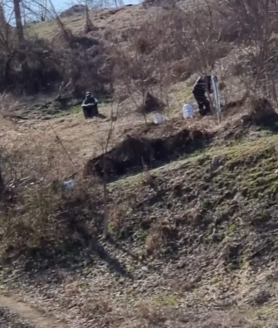 충북 음성군의 한 산업단지 예정지에서 한 남성이 절구통에 유골을 넣어 빻고 있다. (시청자 제공 화면)