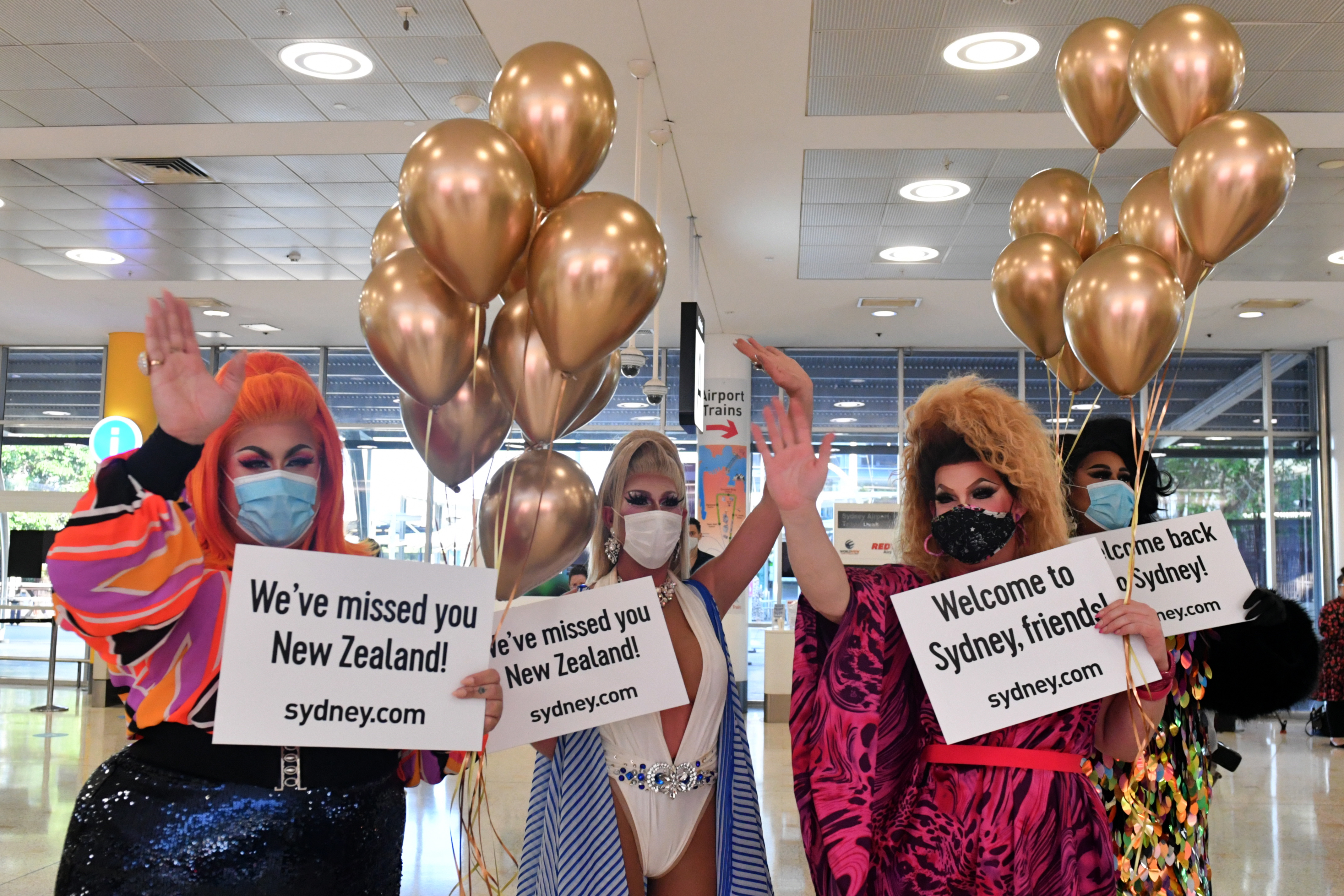 19일 시드니 국제 공항에서 뉴질랜드 여행객을 환영하는 여장 남자들(드래그 퀸즈). [사진 출처 : 연합뉴스]