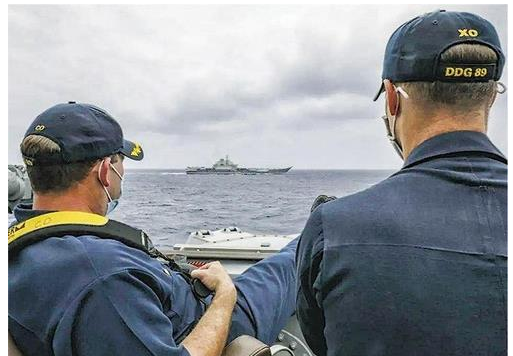 미해군 머스틴함 지휘관이 난간에 다리를 올린채 중국 항공모함 랴오닝을 바라보고 있다. (사진 출처=미 해군)