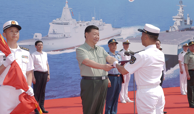 시진핑 중국 국가주석이 4월 23일 해군 창설 72주년을 맞아 하이난성 싼야 해군기지에서 열린 신형 함정 3척의 취역식에 참석해 하이난함 함장에게 인민해방군 깃발과 임명장을 주고 있다. (사진 출처=신화 연합뉴스)