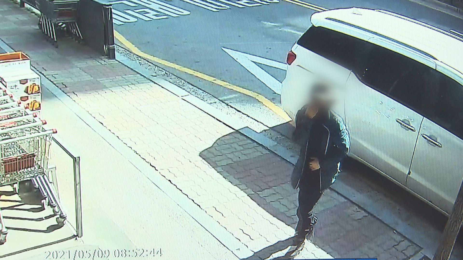마트 CCTV 화면. 윗옷으로 코와 입을 가린 채 한 여성이 마트로 들어오고 있다.