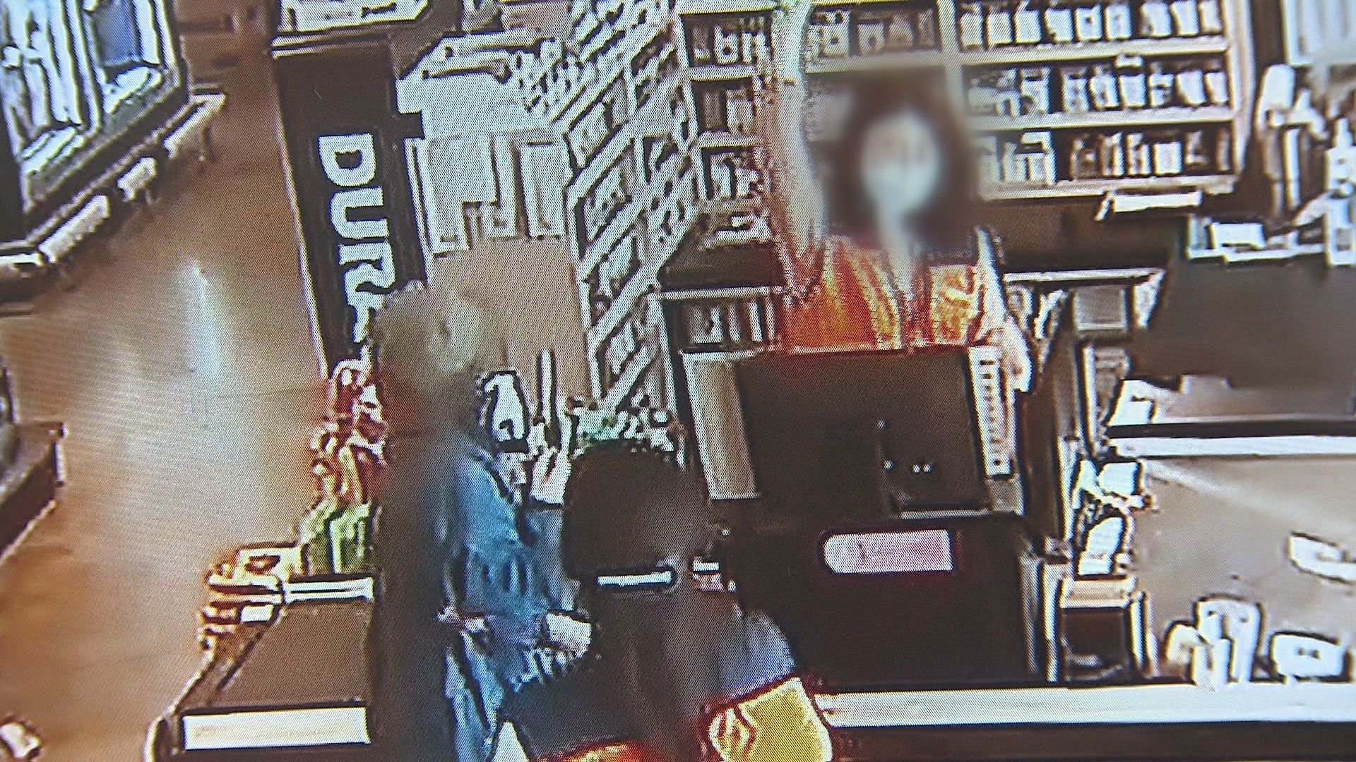 마트 CCTV 화면. 모자를 쓴 여성이 계산대 직원에게 아이스크림을 던진 뒤 화를 내고 있다.