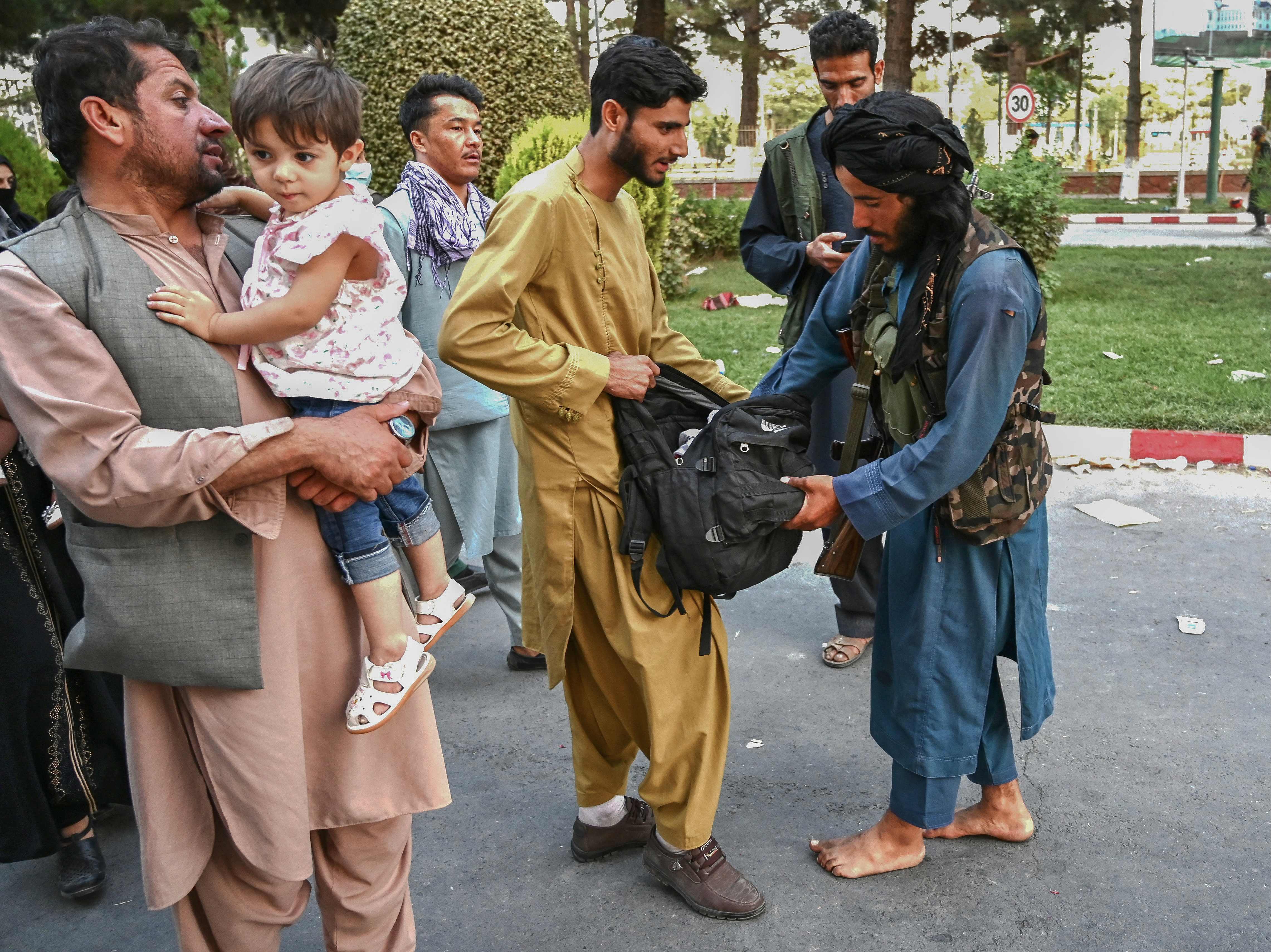 (카불 AFP=연합뉴스) 16일(현지시간) 아프가니스탄 탈레반 반군이 카불 국제공항을 빠져나오는 주민들의 가방을 수색하고 있다.