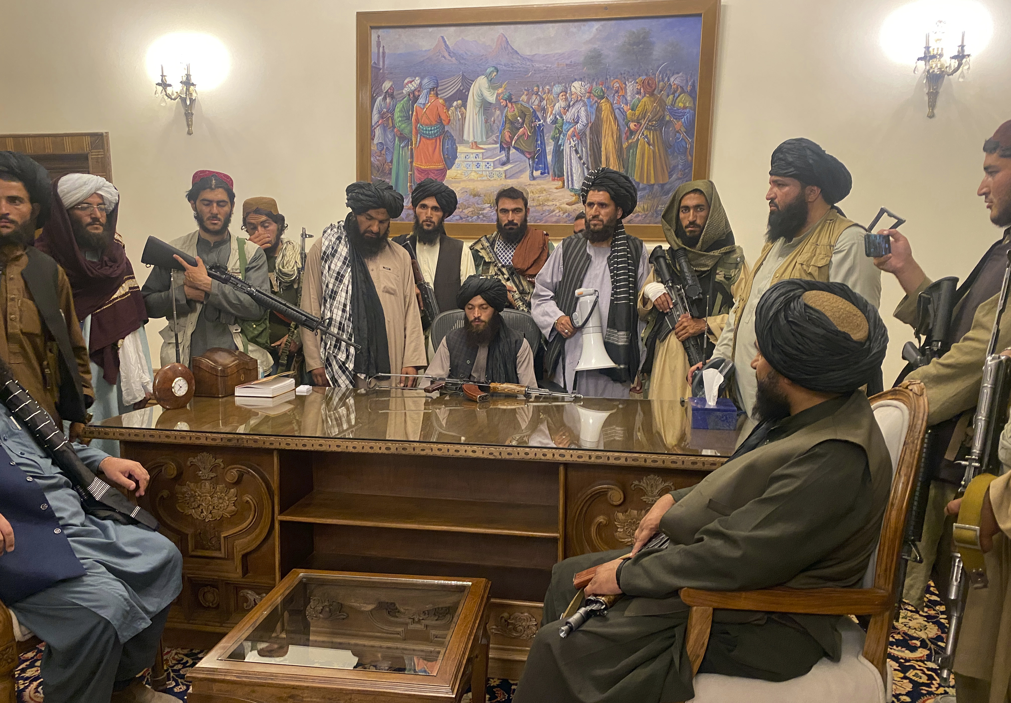 (카불 AP=연합뉴스) 15일(현지시간) 아프가니스탄 카불에서 대통령궁을 점령한 탈레반 지도자들이 해외로 도피한 아슈라프 가니 대통령 자리에 앉아 있다.