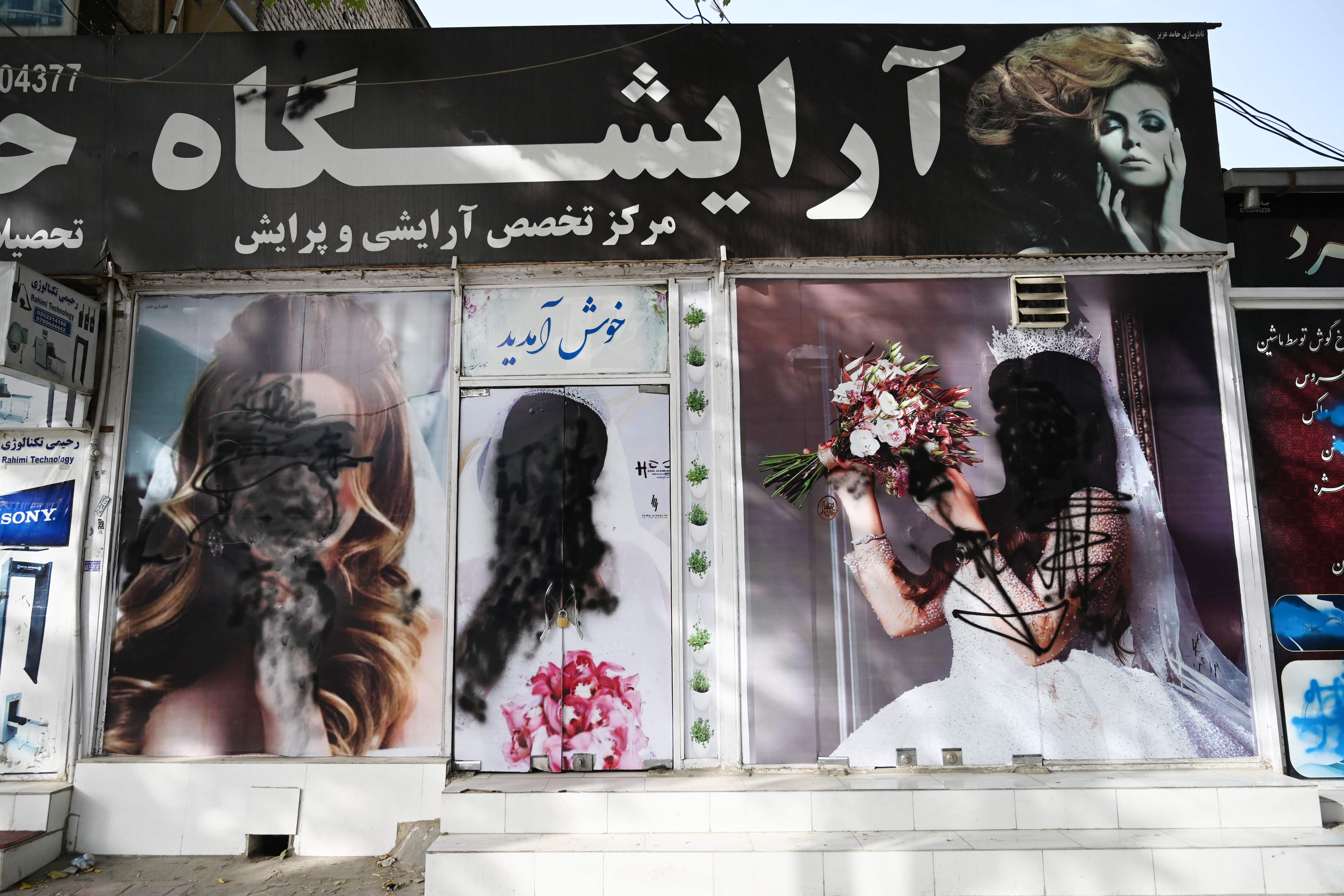 18일(현지시간) 아프가니스탄 수도 카불의 한 미용실. 벽에 내걸린 여성 얼굴 사진에 검은색 스프레이가 칠해져 있다. [사진 출처 : 연합뉴스]