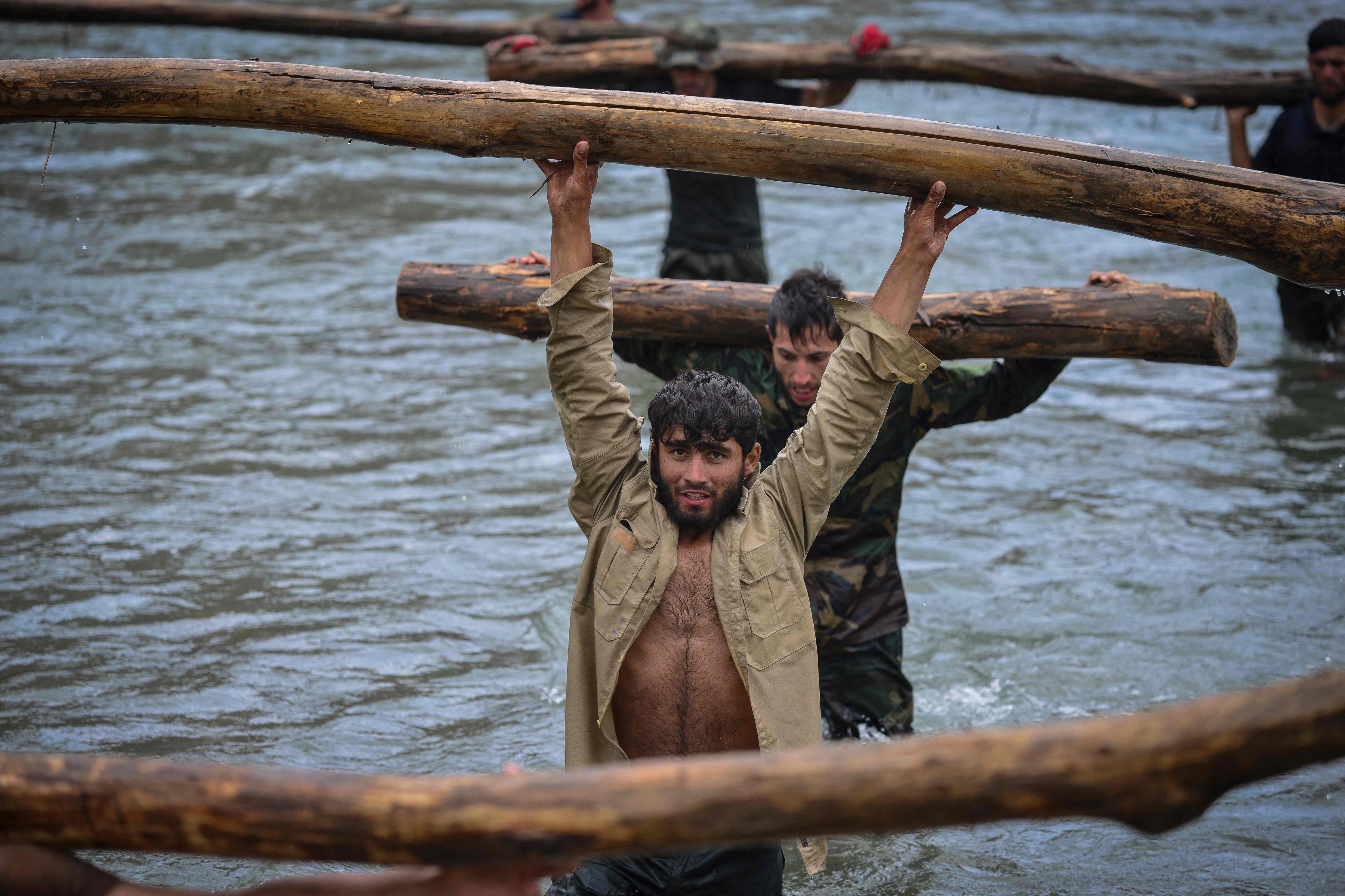 (판지시르 AFP=연합뉴스) 아프가니스탄 북부 판지시르주에서 30일(현지시간) 이슬람 무장 조직 탈레반에 저항하는 정부군과 민병대가 통나무를 들고 물을 건너는 훈련을 하고 있다.