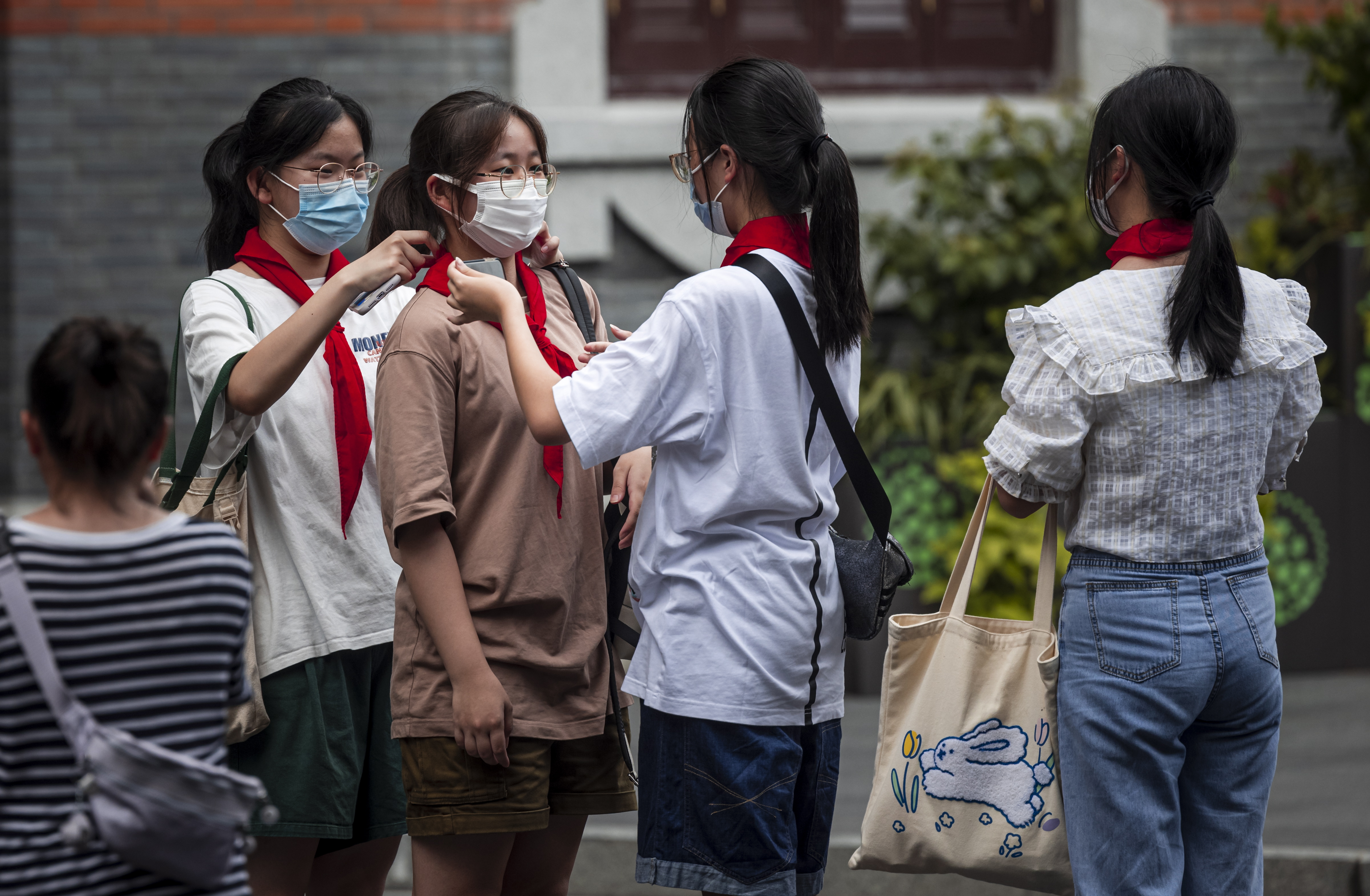(EPA=연합뉴스) 지난달 26일 중국 상하이에서 학생들이 서로 붉은 스카프(홍링진)를 매주고 있다.