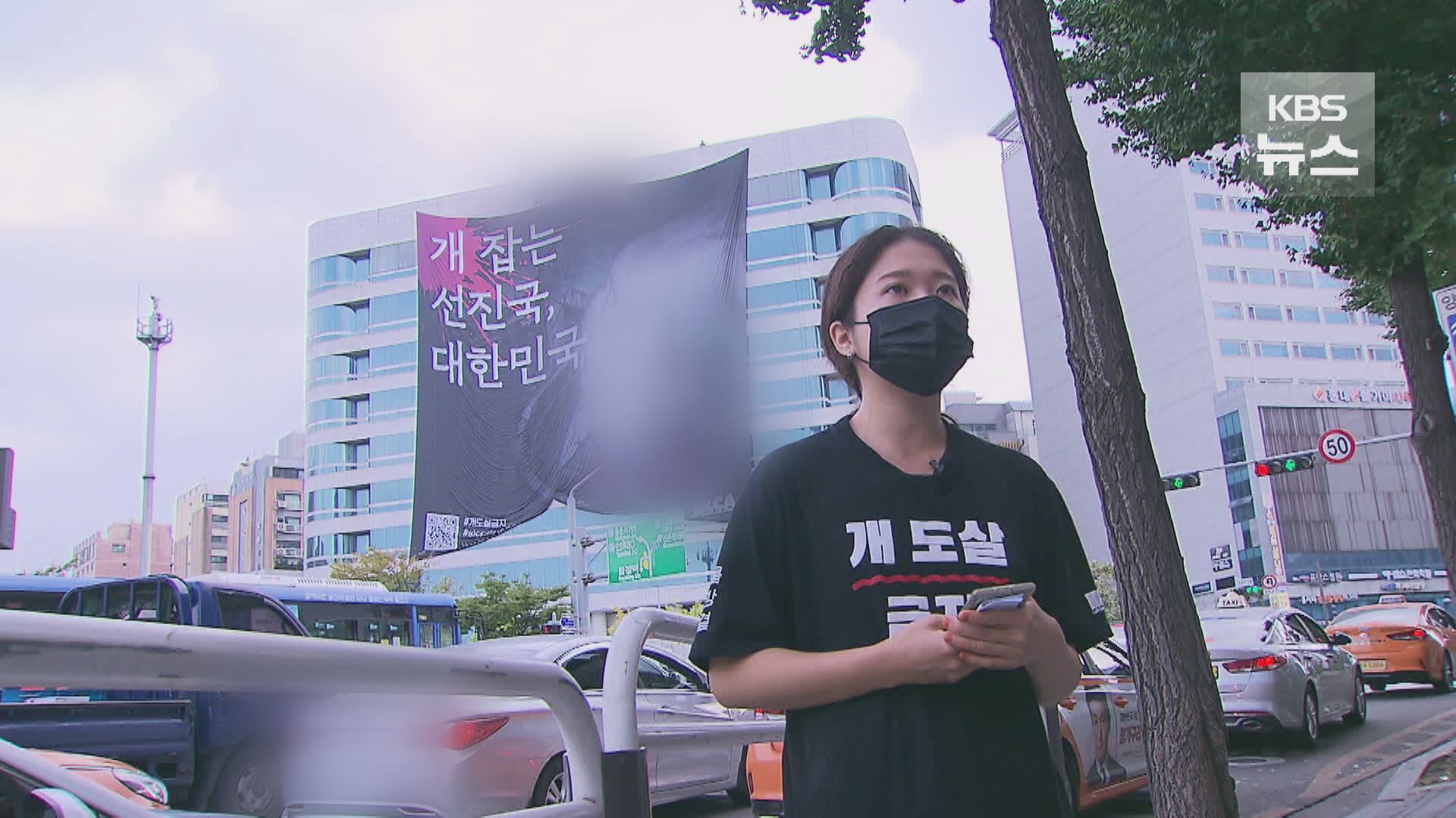 현수막이 걸린 건물 앞에서 기자회견을 하는 동물해방물결 장희지 활동가