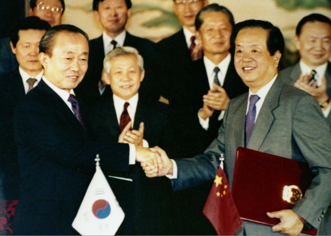 1992년 8월 24일 이상옥 외무부장관(왼쪽)과 첸지천 중국 외교부장이 수교 공동성명에 서명한 뒤 악수하고 있다. (출처=국가기록원)