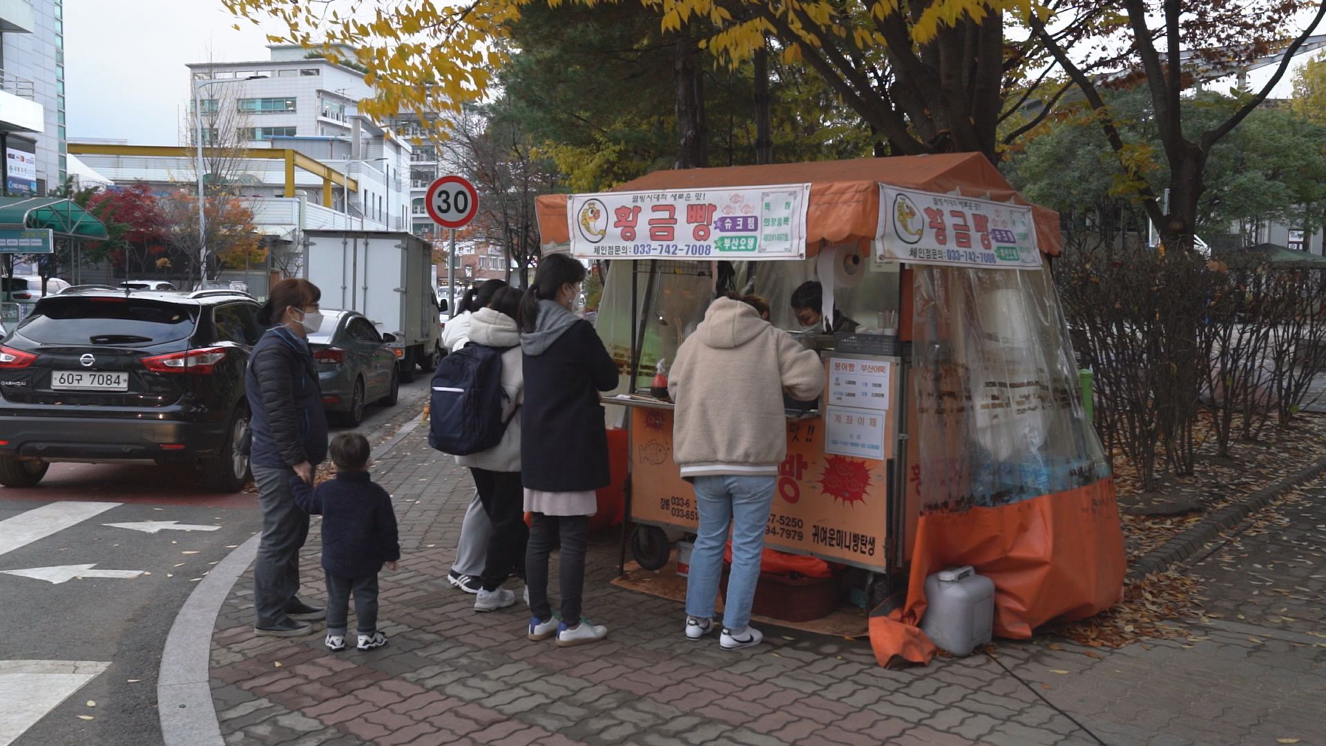 추운 날씨에도 붕어빵 노점 앞에는 사람들이 줄을 서 기다리고 있다.