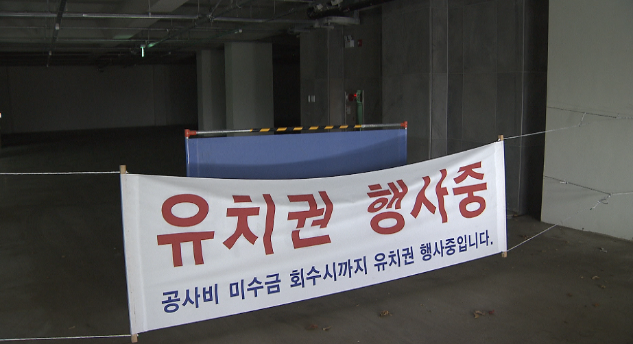 건물 주차장 입구부터 내걸린 ‘유치권 행사’ 현수막.