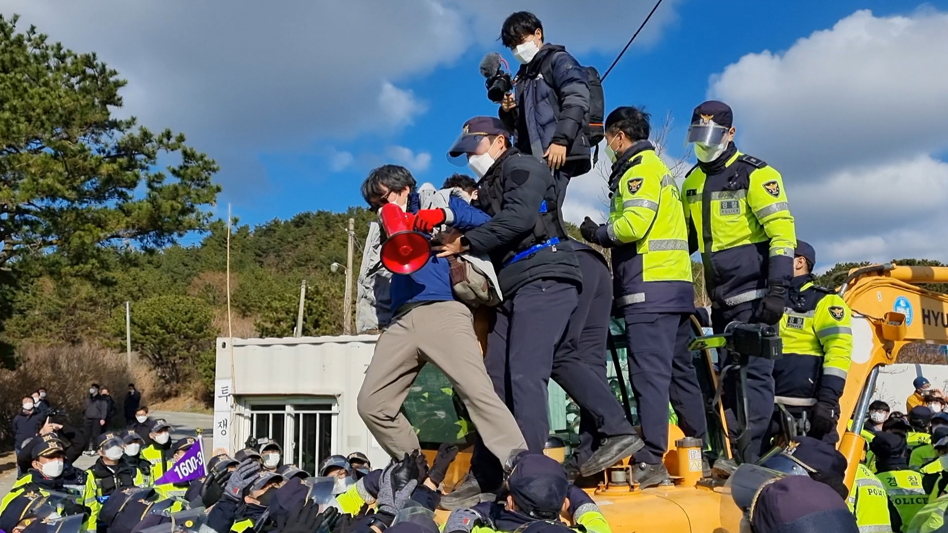7일 오전 부산 해운대구 장산마을에서 굴삭기 위에 올라가 항의하던 시민들을 경찰이 억지로 끌어내리고 있다.
