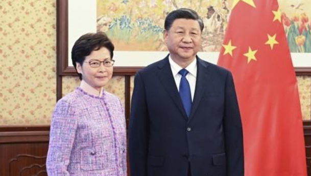 시진핑 중국 국가주석에게 2021년 12월 22일 베이징에서 업무보고를 하며 기념 사진을 찍는 캐리 람 홍콩 행정장관(왼쪽). (사진=연합뉴스)