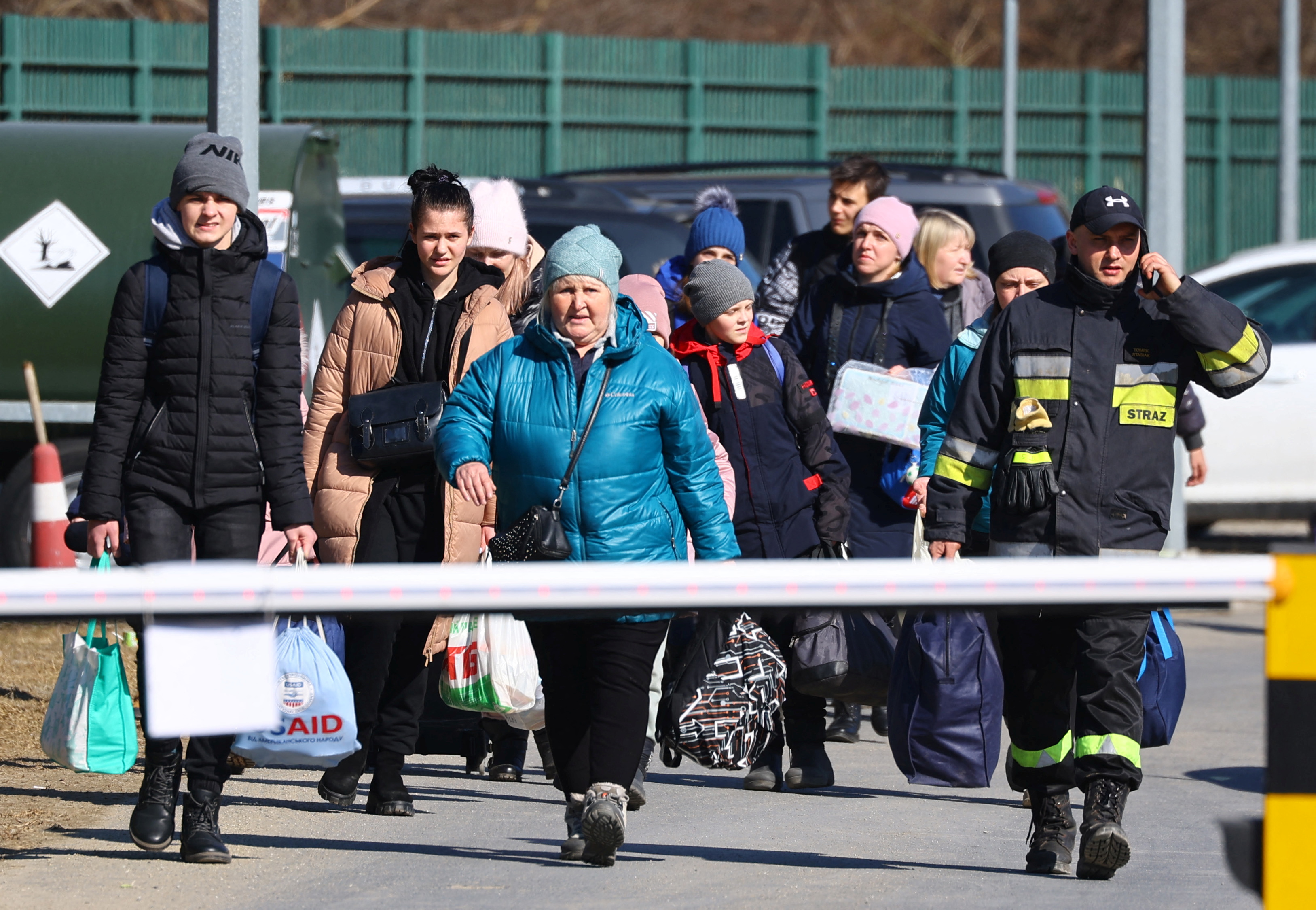 러시아의 공격을 피해 탈출한 우크라이나인들이 지난 17일 우크라이나-폴란드 국경을 넘고 있다. [사진=로이터 연합뉴스]