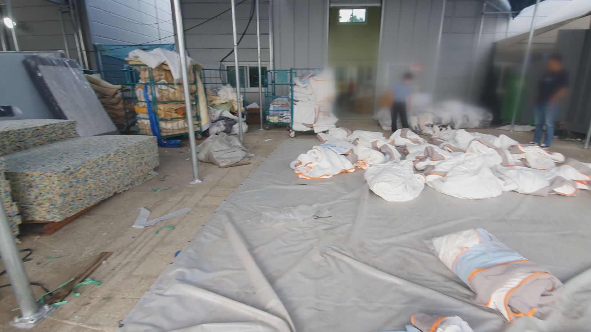 단속에 적발된 침대 매트리스 공장 내부. 중국에서 만든 가짜 커버가 바닥에 나뒹굴고 있다.
