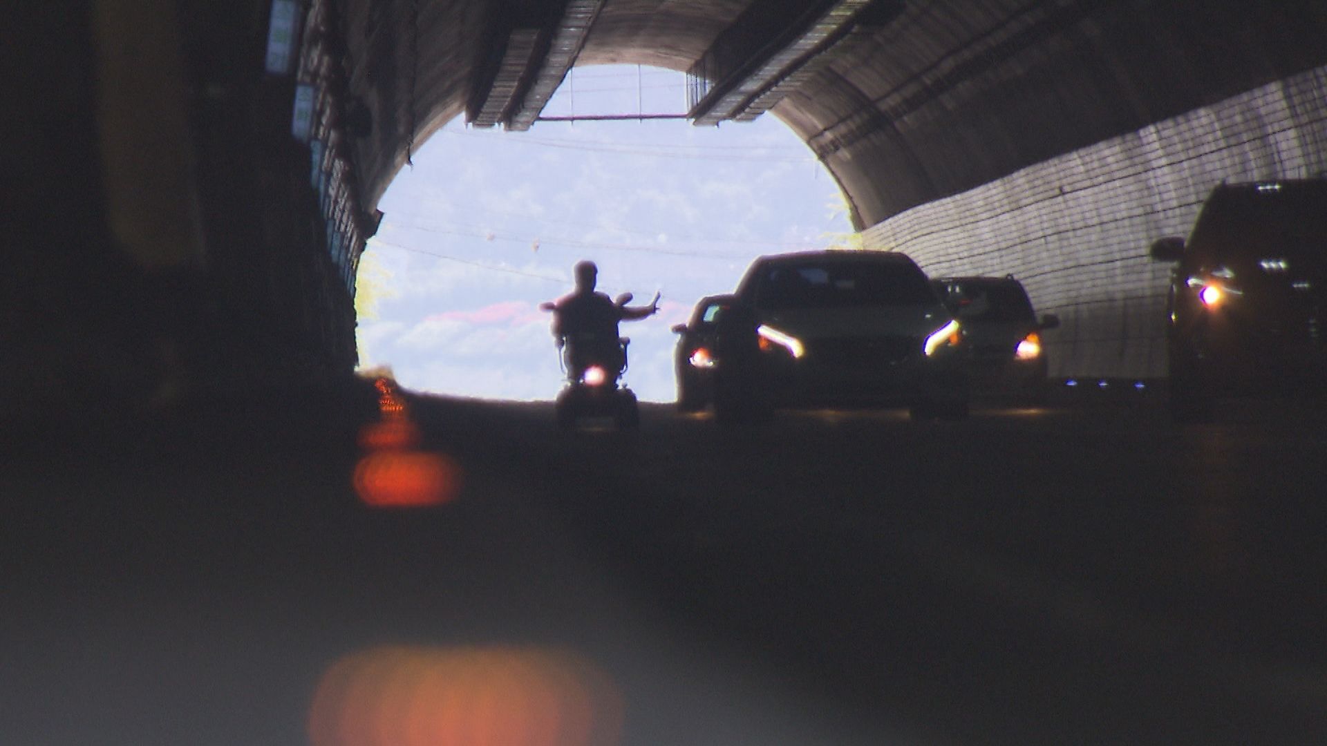 전동휠체어를 탄 김용대 씨가 경적을 울리는 차들에 손짓하며 터널을 건너고 있다. 