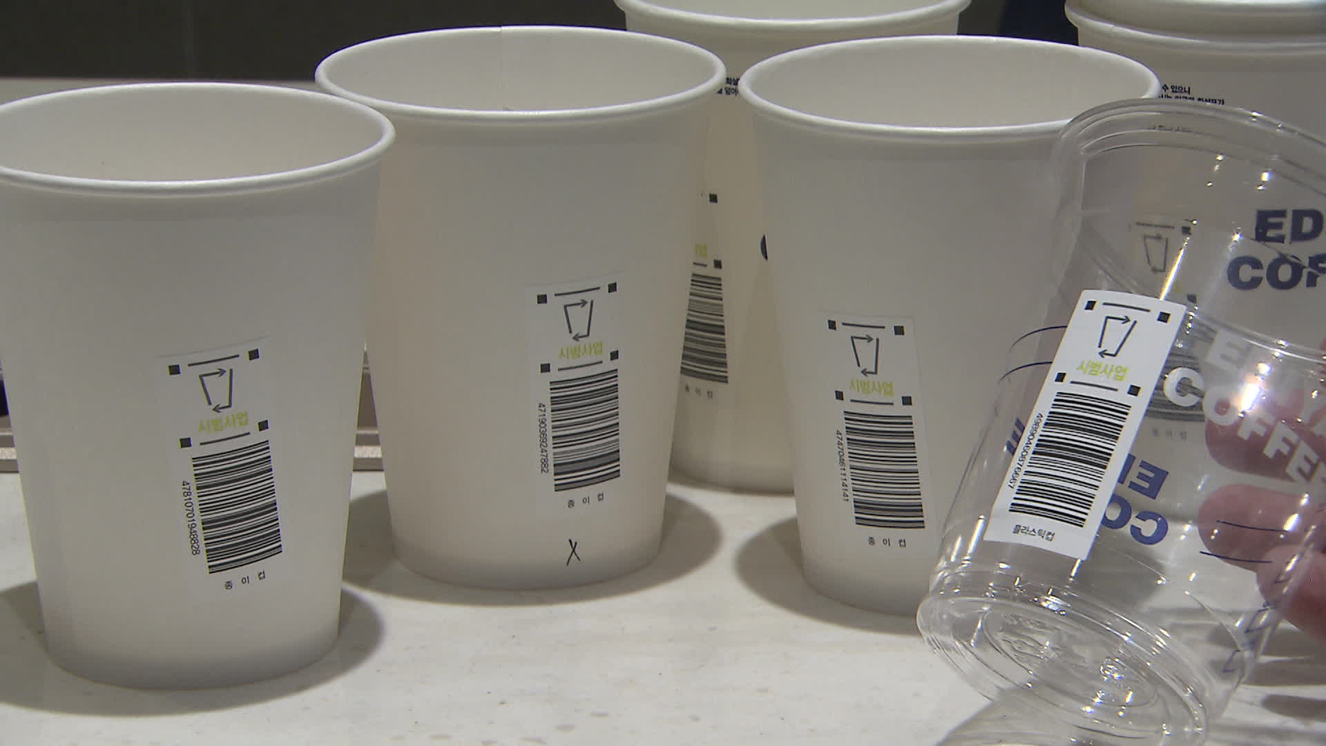 보증금제에 사용되는 재활용 바코드가 붙은 일회용 종이컵과 플라스틱 컵