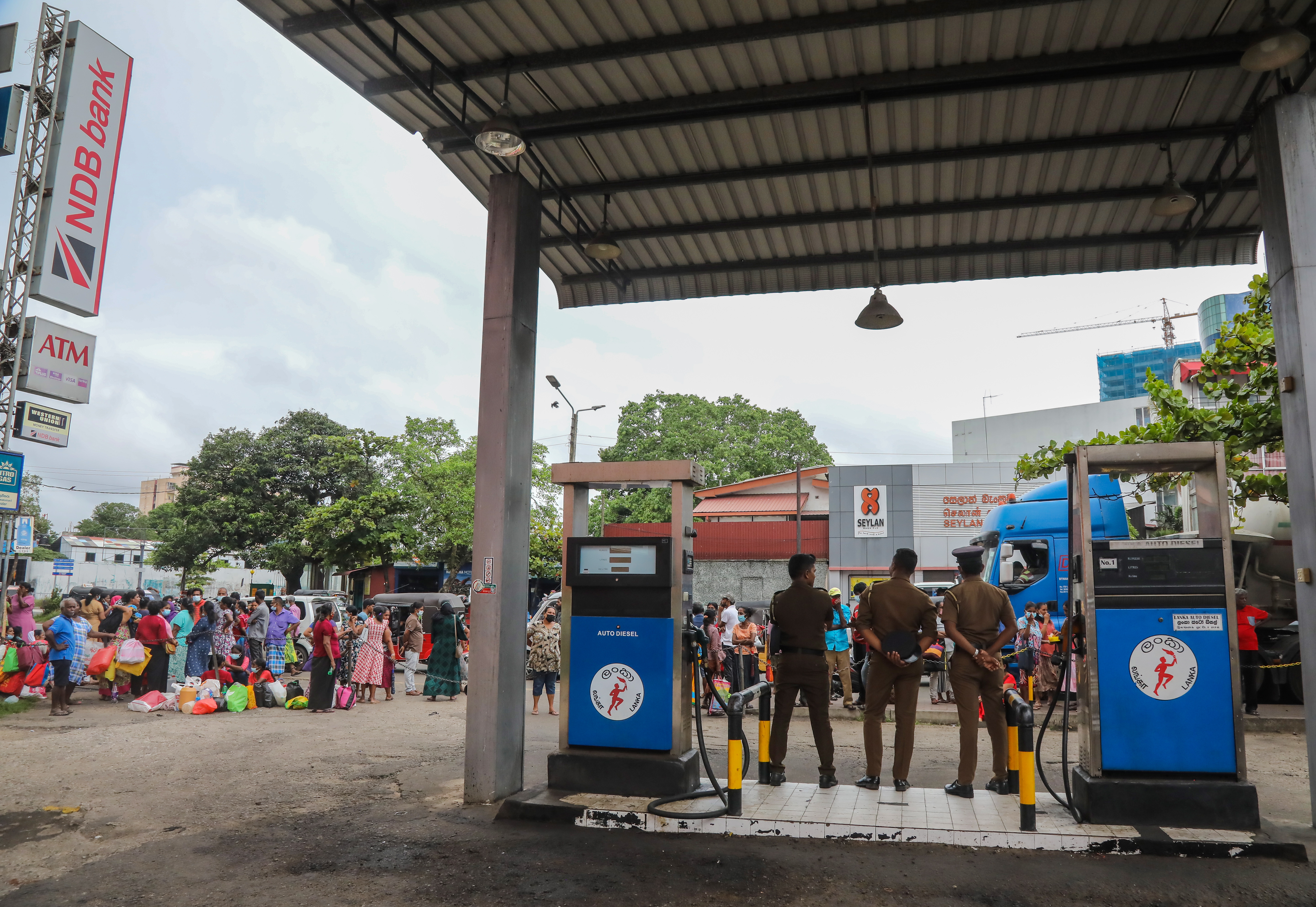 스리랑카 수도 콜롬보에서 기름을 사기 위해 줄을 선 사람들과 주유소를 지키는 경찰(2022.06.07.)