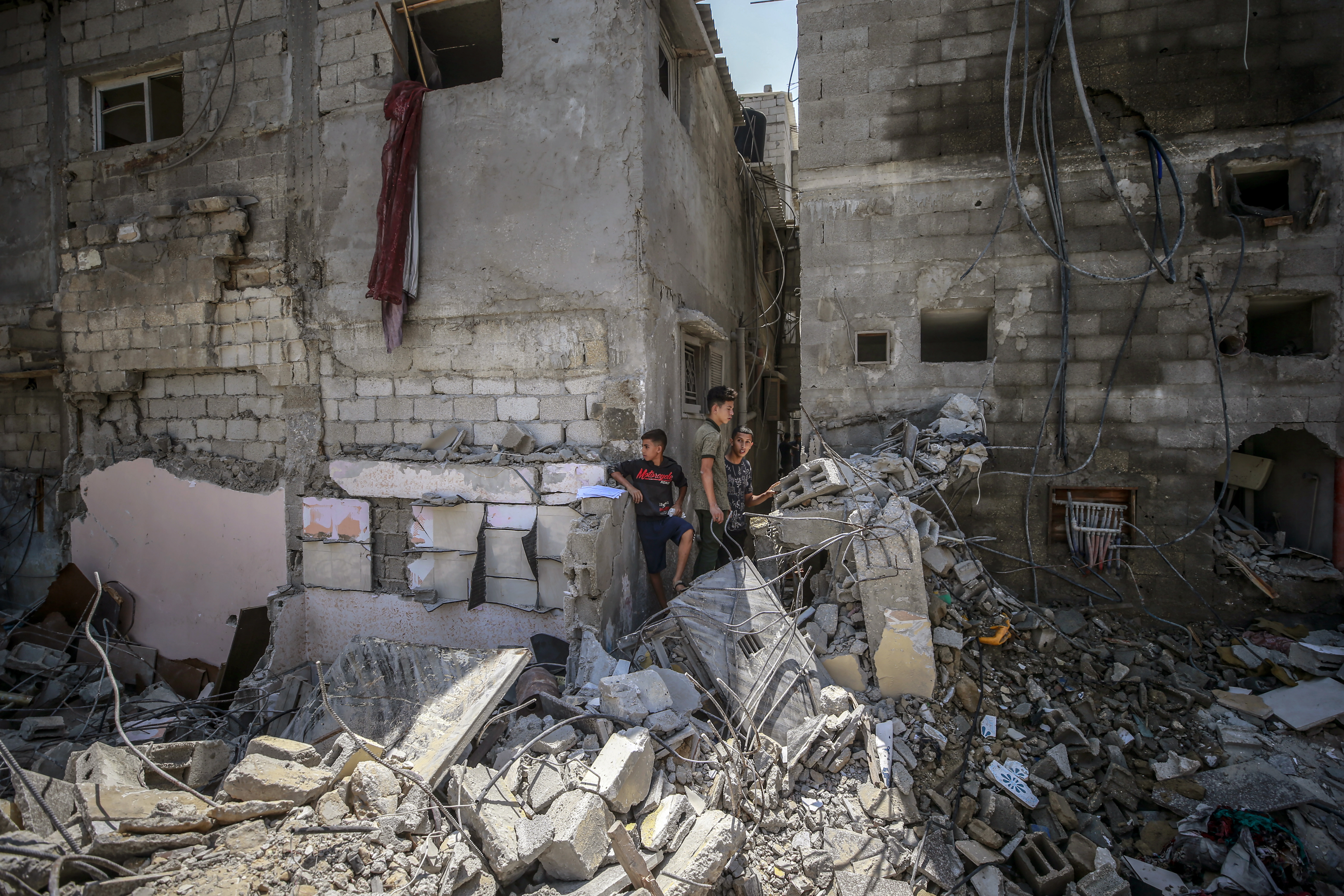 공습으로 폐허가 된 집을 보고 있는 팔레스타인 주민과 아이들(현지시각 7일, 가자지구/EPA)