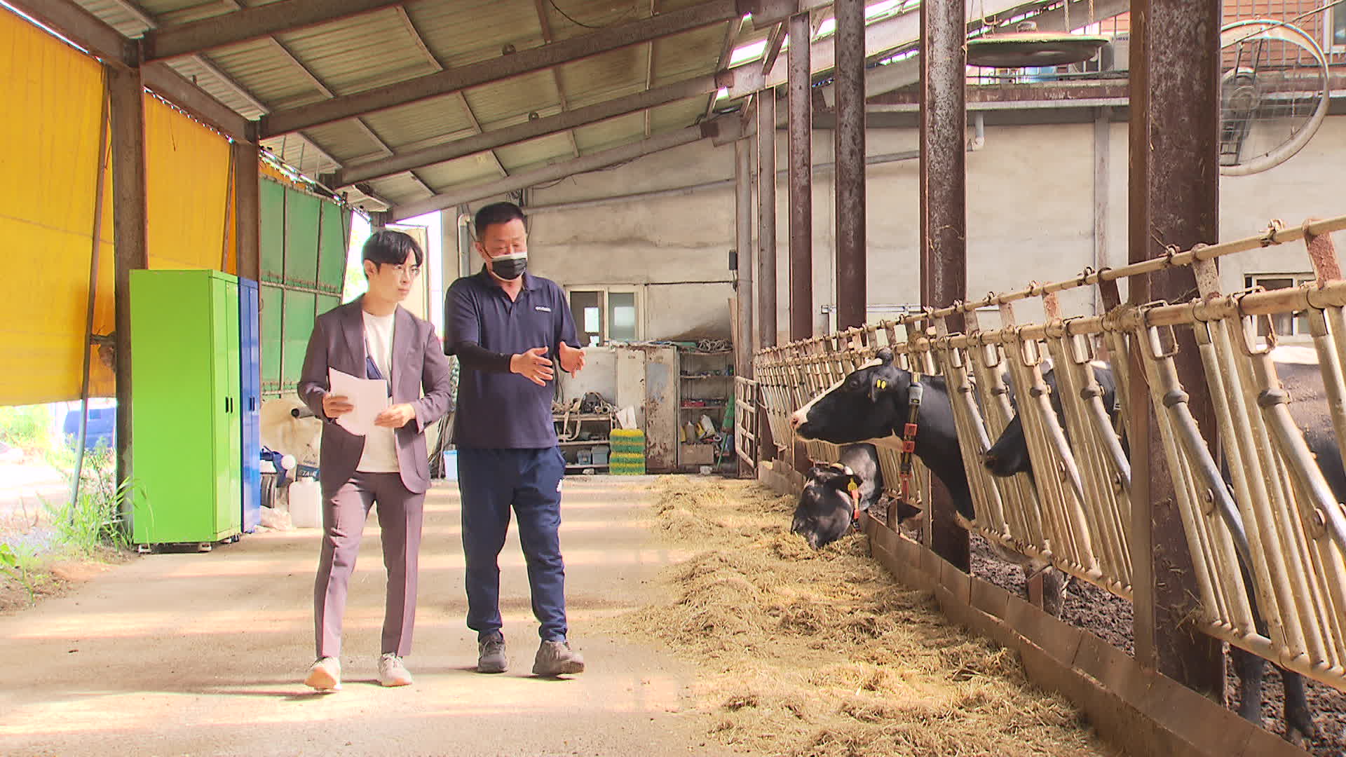 경기도 이천의 젖소농장에서 기자(왼쪽)가 주인으로부터 사료에 관한 설명을 듣고 있다. [촬영기자 조은경]