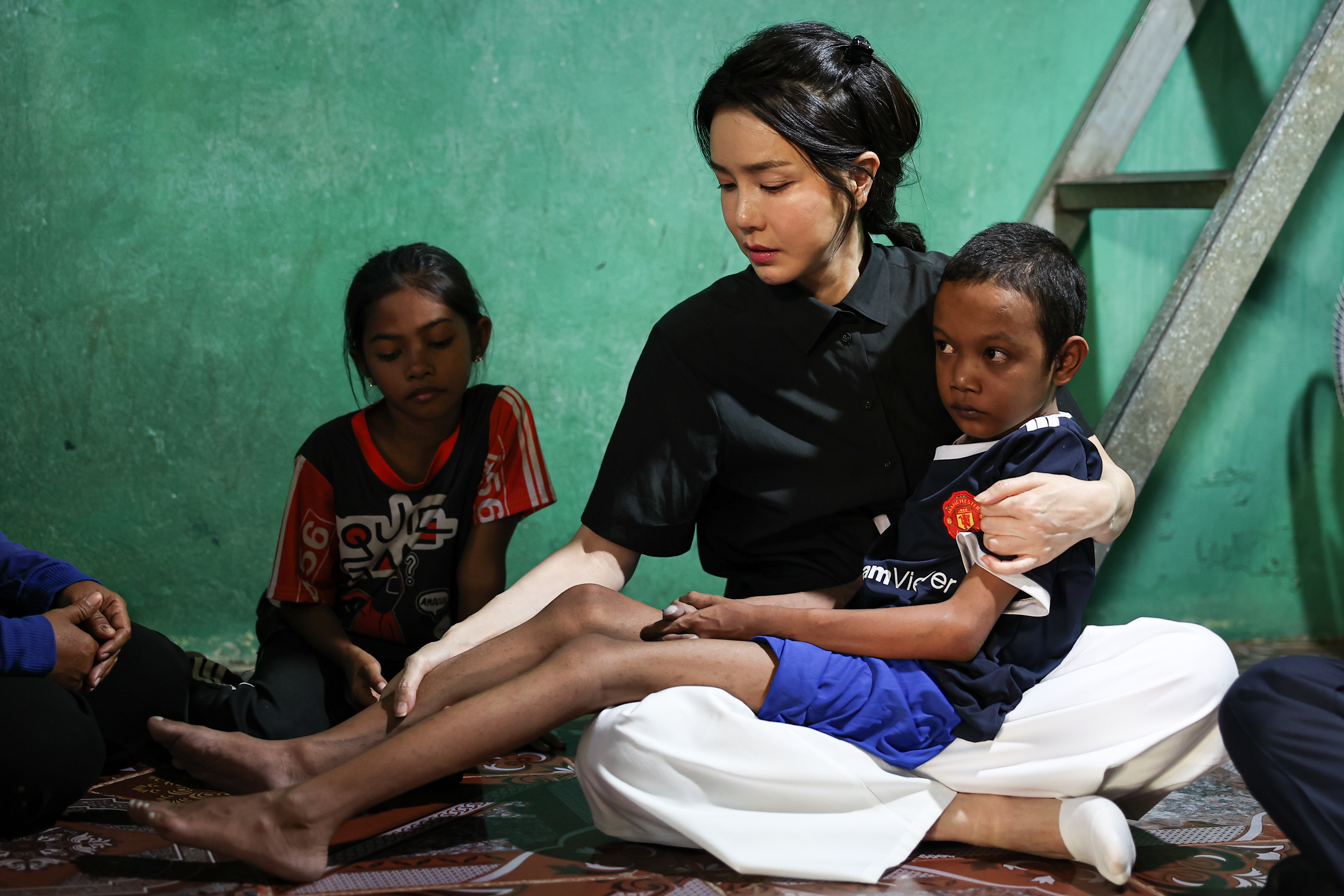김건희 여사가 12일(현지시간) 캄보디아 프놈펜의 선천성 심장질환 환아 로타의 집을 찾아 로타의 상태를 살펴보고 있다.