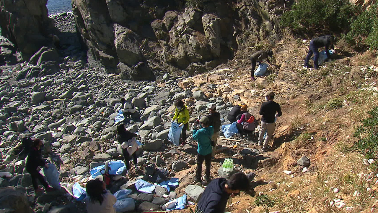 쓰레기가 쌓인 학림도의 해안을 자원봉사자 등이 치우고 있다.