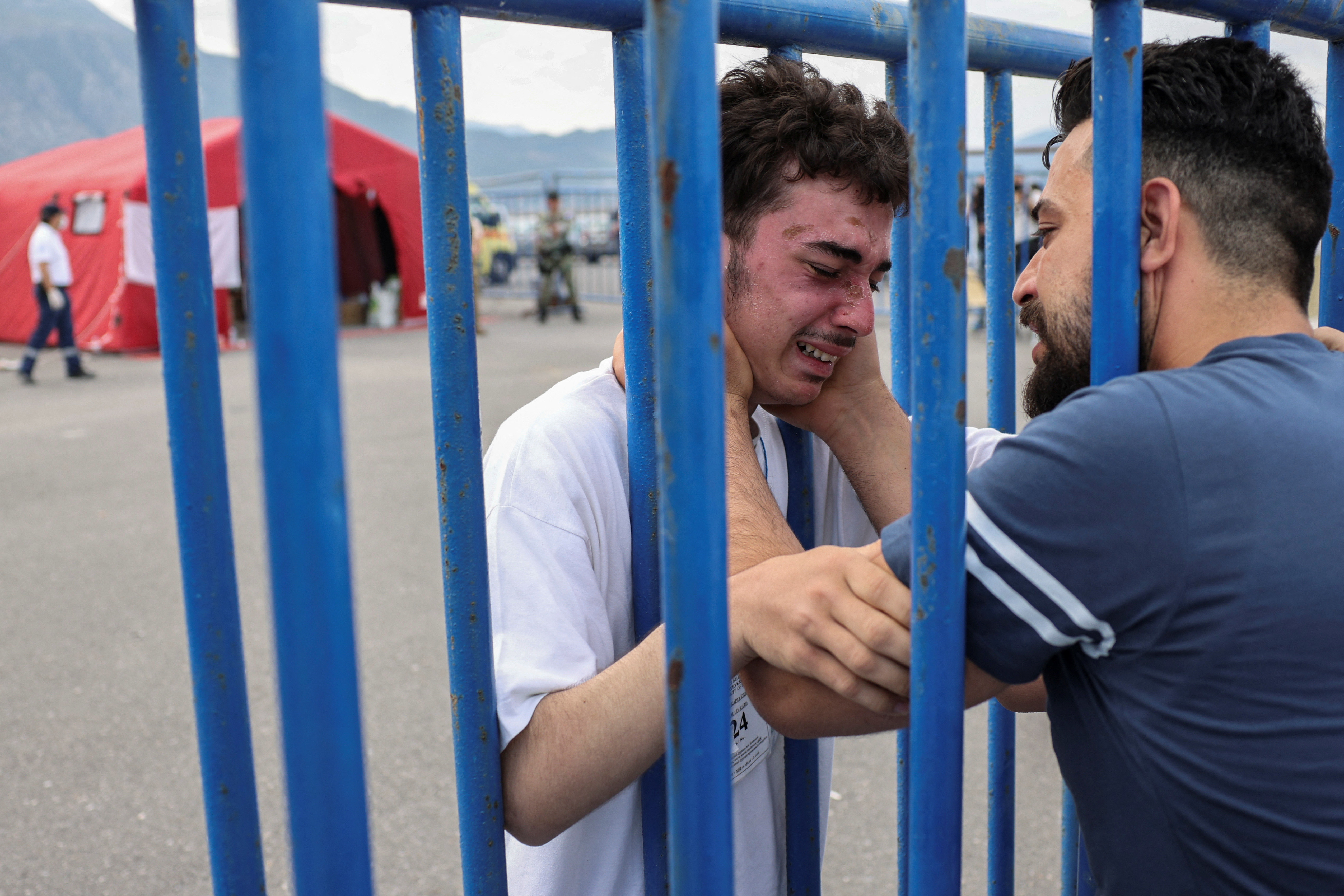 그리스 앞바다 난민선 침몰 사고의 생존자가 가족과 재회하며 울고 있다.