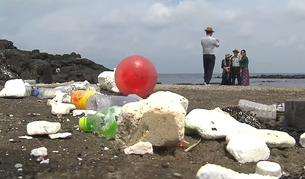 우도 비양도 해안에서 관광객들이 해양쓰레기를 피해 사진을 찍는 모습