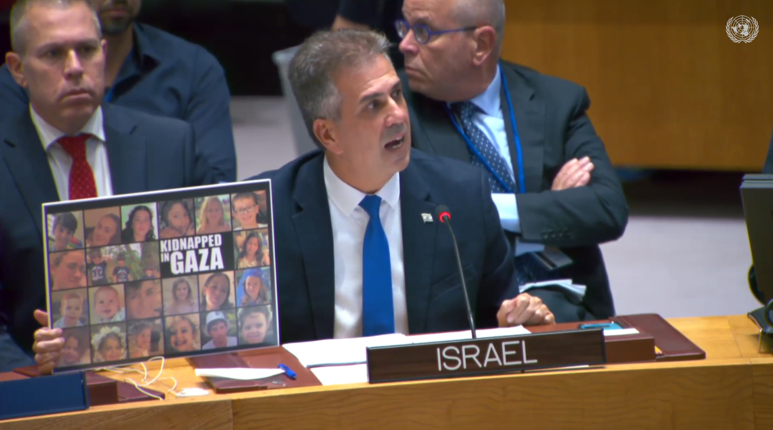 현지 시각 24일 엘리 코헨 이스라엘 외교장관이 유엔 안보리에서 납치된 어린이들의 사진이 담긴 팻말을 들고 있다.