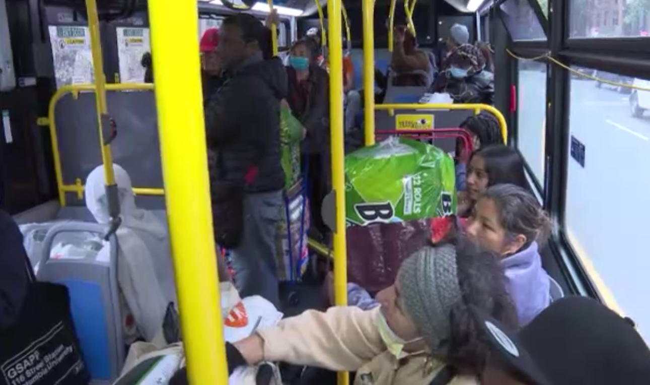 무료 버스 승객들이 짐을 잔뜩 안은 채 버스를 이용하고 있다
