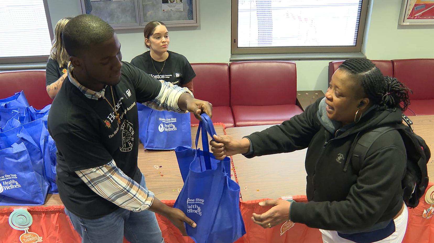 뉴욕 브롱스 호느토스 칼리지 먹거리 나눔터에서 학생이 음식이 든 가방을 받아가고 있다.