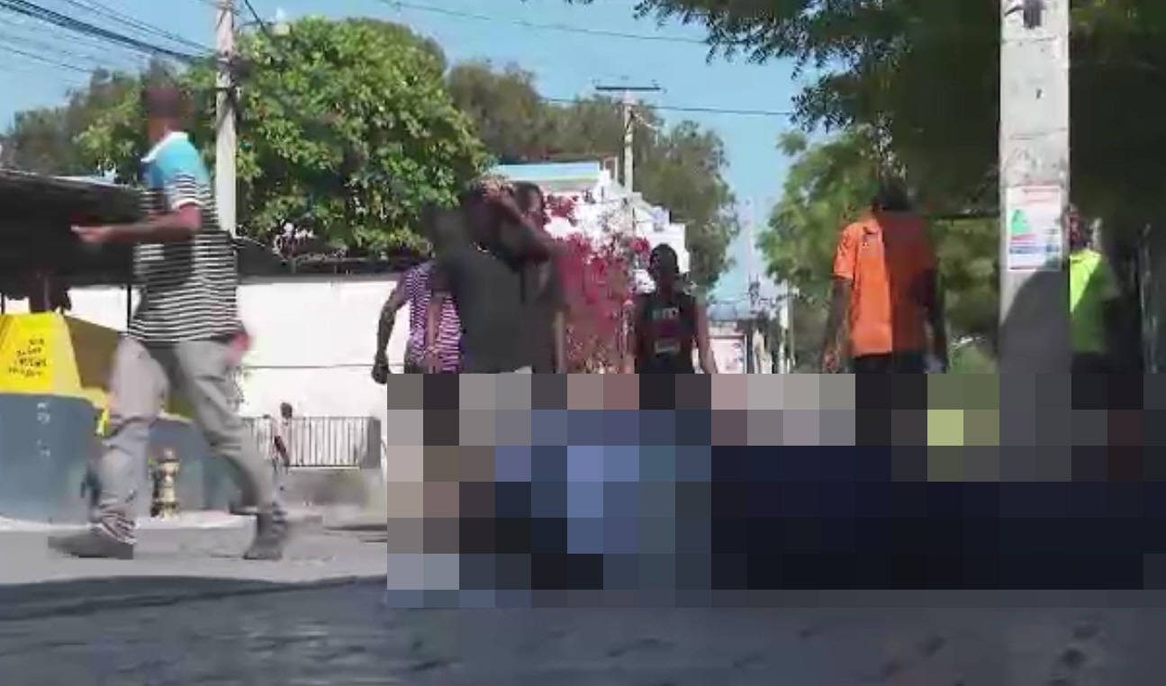 아이티 수도 포르토프랭스에서 시민들이 시신 옆으로 걸어 다니고 있다. AP 영상 갈무리