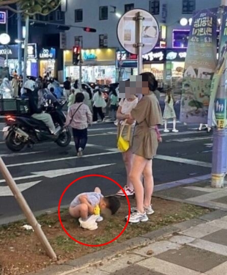 지난 17일 밤 제주시 연동 한 길거리에서 중국인 관광객 가족이 대변을 보게 하는 모습. 112에 관련 신고가 들어가기도 했다. (사진 출처 : 온라인 커뮤니티)