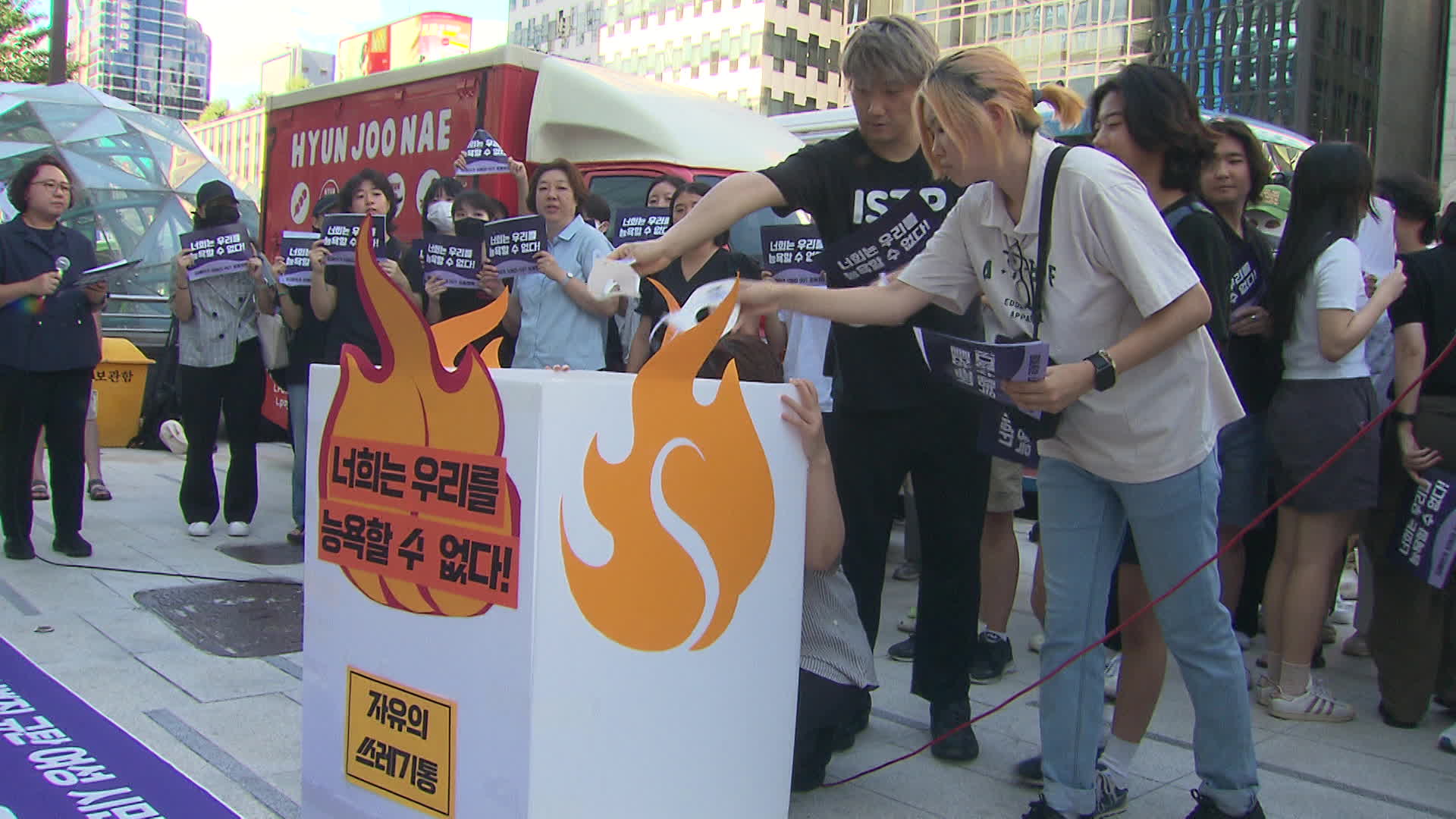 쓰고 있던 가면을 쓰레기통에 버리는 퍼포먼스를 진행 중인 참가자들