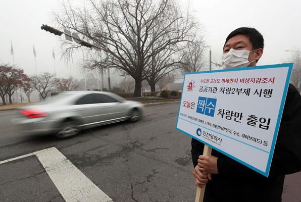 수도권 미세먼지 비상저감조치로 공공부문 차량 2부제가 시행되면서 인천시 남동구 인천시청사 앞에서 시청 직원이 차량 2부제 시행을 홍보하고 있다.