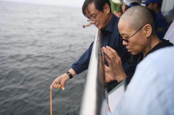 노벨평화상 수상자인 중국의 인권운동가 류샤오보의 유골 단지가 15일(현지시각) 중국 랴오닝 성 다롄 앞바다 물속으로 내려지는 모습을 아내 류샤(오른쪽)가 지켜보고 있다. (사진=AP)