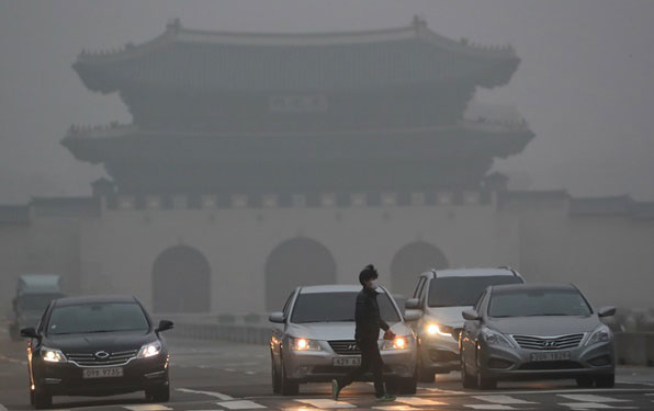 미세먼지와 안개 때문에 현판이 보이지 않는 오늘 오전 서울 광화문 모습. 자동차는 전조등을 밝혔고 행인은 마스크를 착용했다.