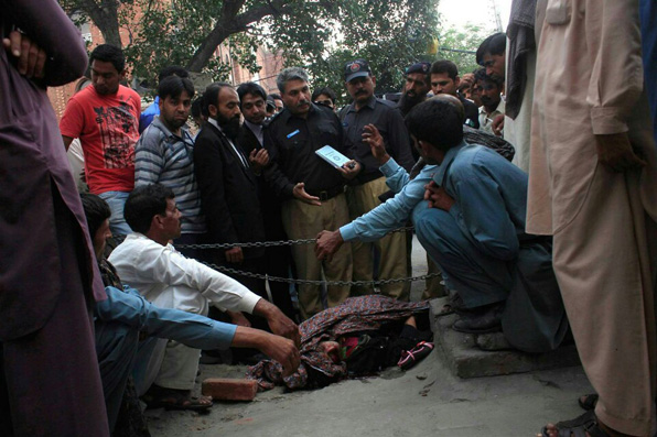 2014년 5월 27일 파키스탄 경찰이 “사랑하는 남성과 결혼했다”는 이유로 이른바 ‘명예 살인’을 당한 한 여성의 시신 주변에서 증거를 수집하고 있다. (사진=EPA)