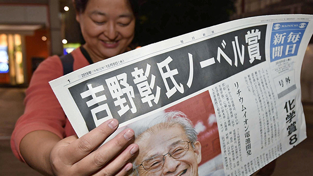 지난해 10월 일본 도쿄 시내 거리에서 행인이 요시노 아키라가 노벨 화학상 수상자로 결정됐다는 호외 신문을 읽고 있다. [사진 출처 : 교도=연합]