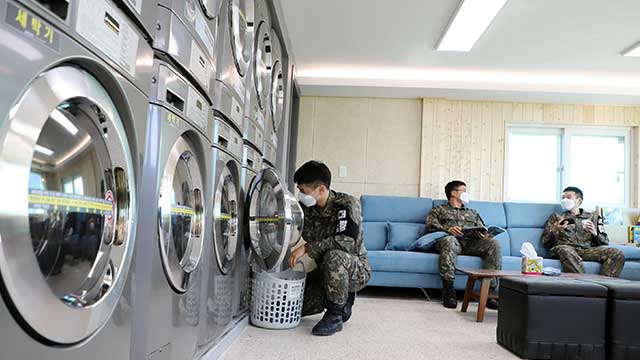 육군 25사단 장병들이 병영세탁방에서 세탁기와 건조기를 이용하면서 책을 읽고 있다. [사진 제공 : 육군]