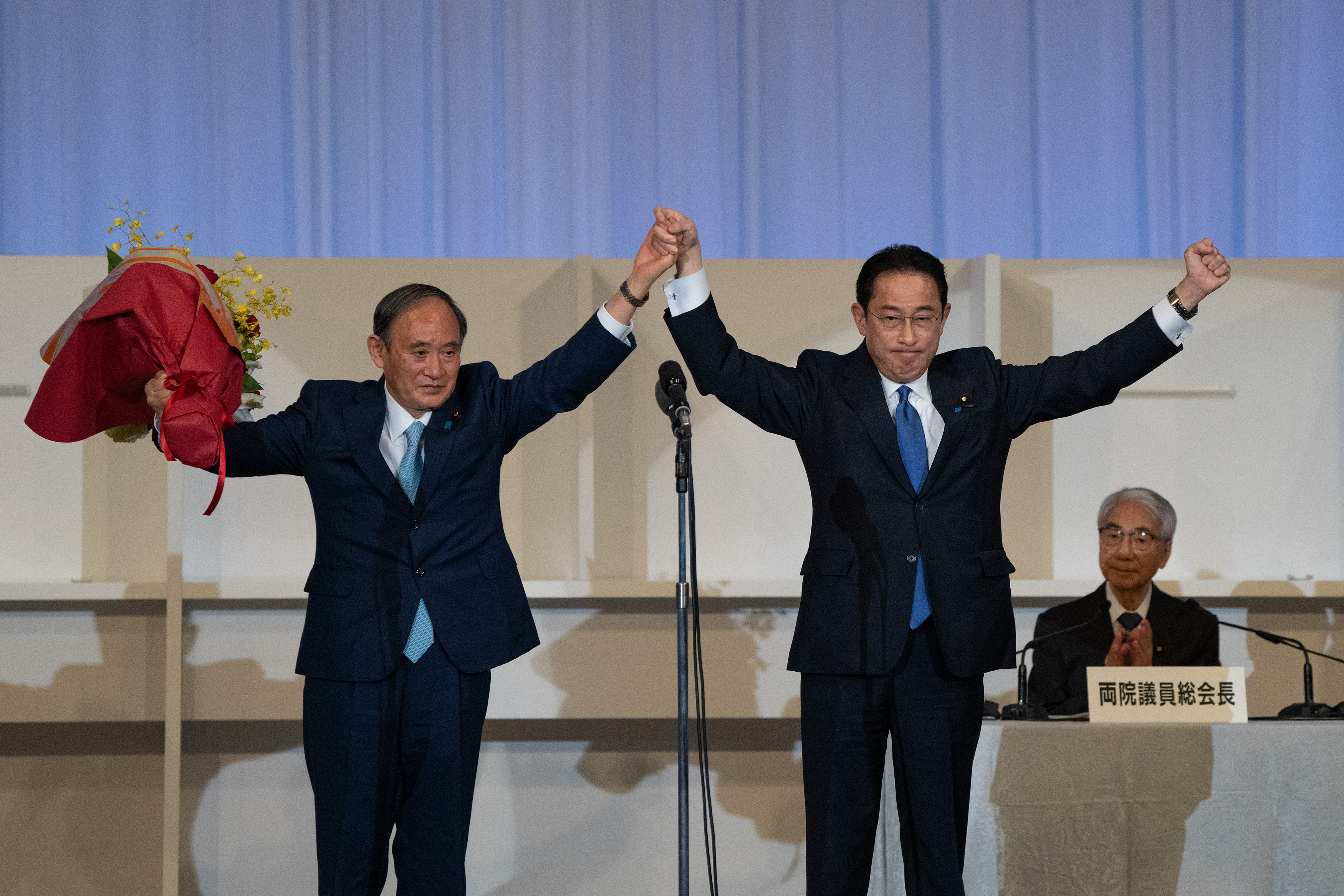 지난달 29일 일본 자민당 총재 선거에서 승리해 차기 총리로 확정된 기시다 후미오 후보를 스가 전 총리가 축하하고 있다.[사진=AP 연합뉴스]