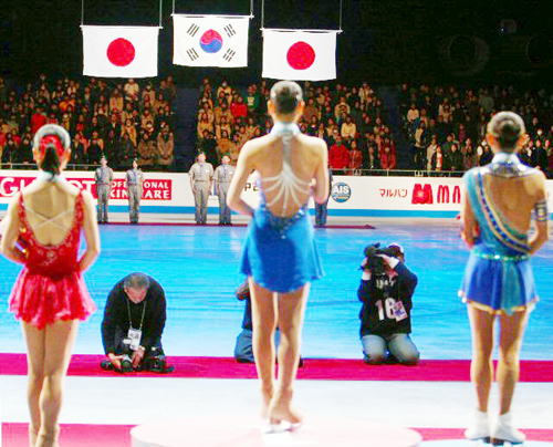 5일 일본 도쿄 요요기 제1체육관에서 열린 '2009 ISU 그랑프리 파이널' 프리스케이팅에서 안도 미키에 역전해 우승한 피겨퀸 김연아가 시상대에서 태극기를 바라보고 있다. 왼쪽은 3위 스즈키 아키코 오른쪽은 2위 안도 미키.