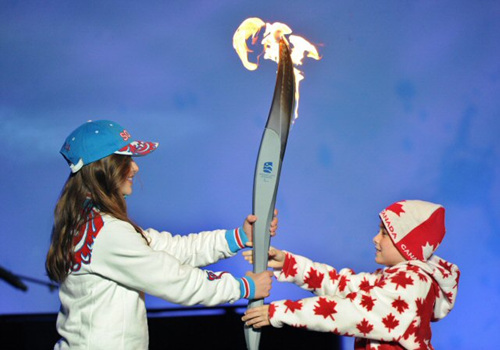 22일(현지시각) 밴쿠버 동계장애인올림픽 폐막식에서 캐나다 소년(오른쪽)이 러시아 소녀에게 성화를 전달하고 있다. 제11회 동계 장애인올림픽은 2014년 러시아 소치에서 개최된다.