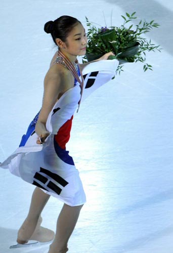 27일 오후 이탈리아 토리노 팔라벨라 빙상장에서 열린 2010 ISU 세계 피겨스케이팅 선수권 여자 싱글, 은메달을 차지한 김연아가 시상식을 마친 뒤 태극기를 들고 관중들에게 인사를 하고 있다.