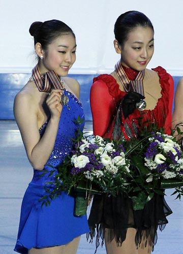27일 오후 이탈리아 토리노 팔라벨라 빙상장에서 열린 2010 ISU 세계 피겨스케이팅 선수권 여자 싱글, 은메달을 차지한 김연아(왼쪽)가 시상식에서 1위 아사다 마오(일본)와 함께 메달을 들어보이고 있다.