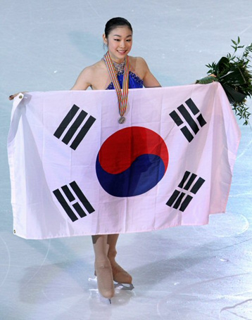 27일 오후 이탈리아 토리노 팔라벨라 빙상장에서 열린 2010 ISU 세계 피겨스케이팅 선수권대회 여자 싱글에서 은메달을 차지한 김연아가 시상식을 마친 뒤 태극기를 들고 기념촬영을 하고 있다.