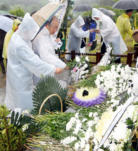 18일 오전 광주 북구 운정동 국립 5.18민주묘지에서 5.18 30주년 기념식이 열리고 있는 가운데 별도의 기념식이 치러지고 있는 5.18 구묘역에서 시민들이 열사들의 묘지에 헌화를 하고 있다.